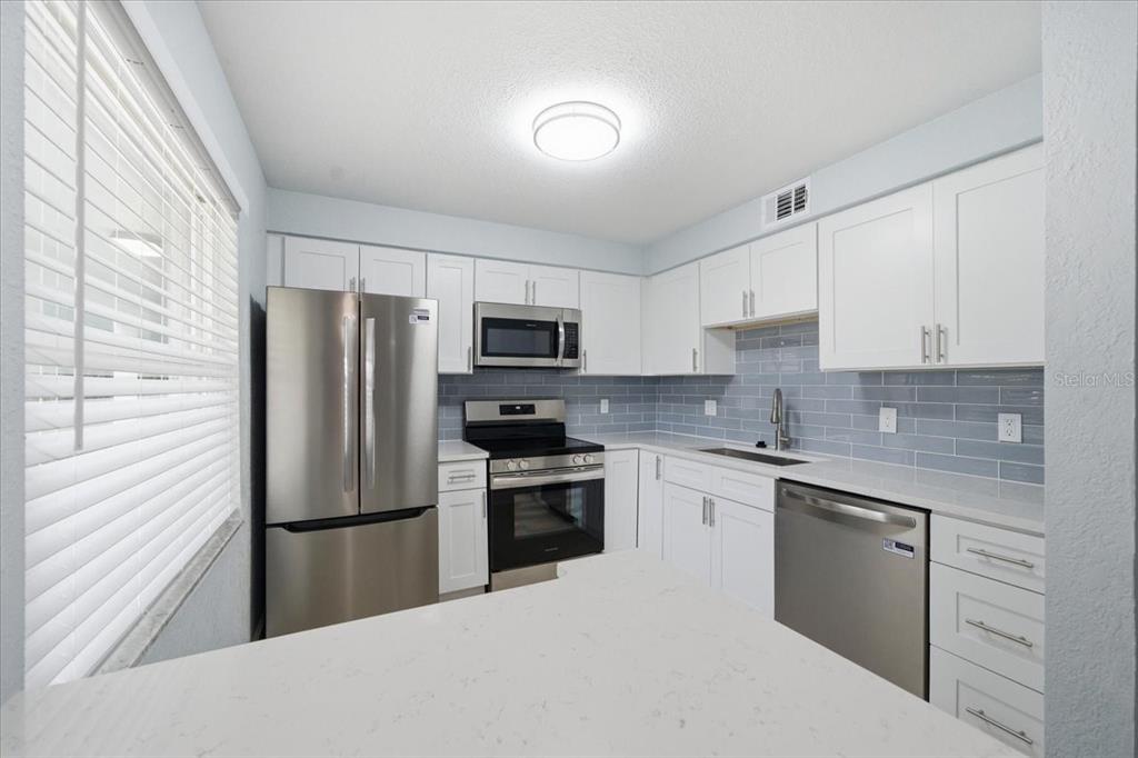 17035 Gulf Boulevard, Unit 118 North Redington Beach, FL 33708 - Photo 17 of 44 a kitchen with cabinets stainless steel appliances and sink