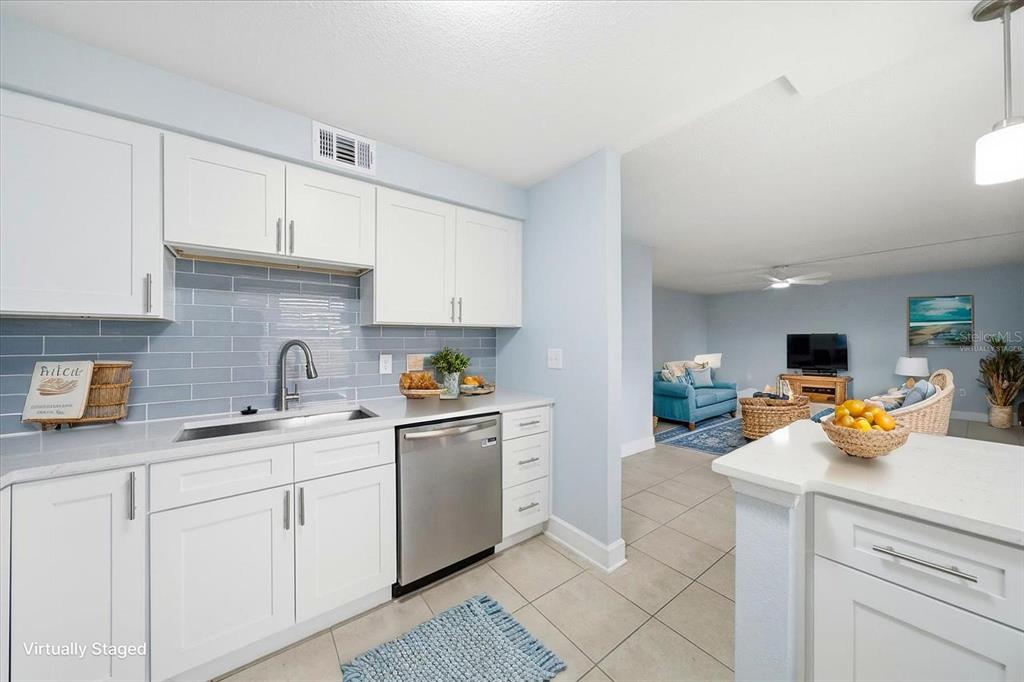 17035 Gulf Boulevard, Unit 118 North Redington Beach, FL 33708 - Photo 20 of 44 a kitchen with a sink dishwasher stove and white cabinets with wooden floor