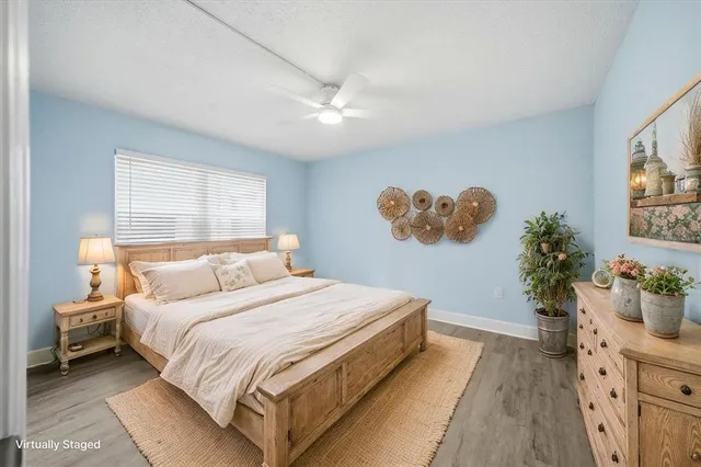 a bedroom with a large bed and a potted plant