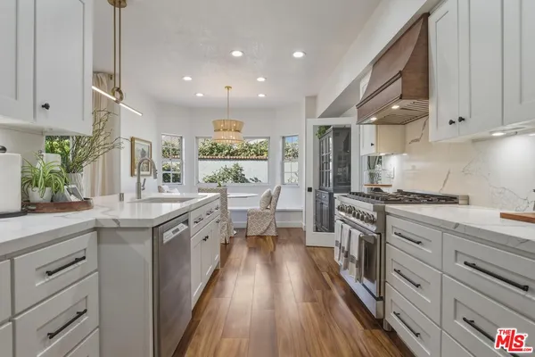 a large kitchen with stainless steel appliances granite countertop a lot of counter space and wooden floors