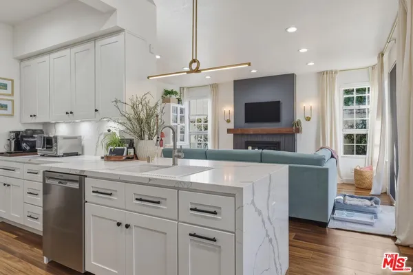 a kitchen with cabinets a sink and a stove with wooden floor