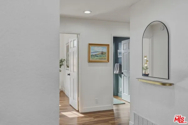 a view of a hallway with wooden floor and staircase