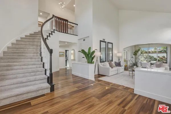 a view of an entryway with wooden floor and a livingroom