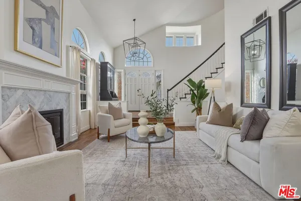 a living room with furniture chandelier and a fireplace