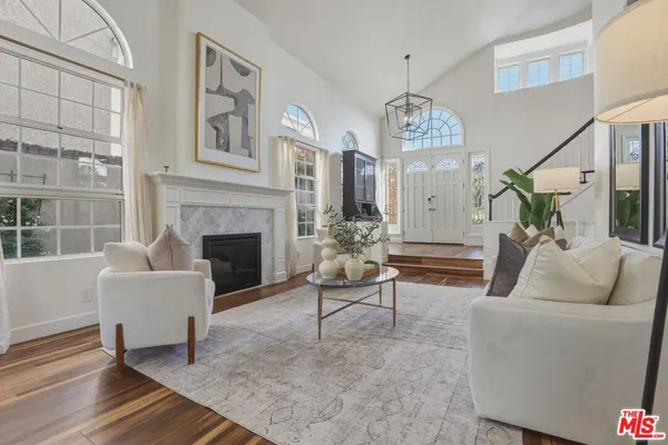 a living room with furniture a fireplace and a chandelier
