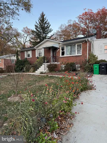 a front view of house with yard and trees around