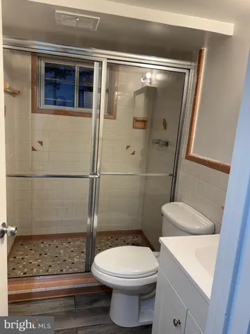 a view of a hallway with wooden floor and closet