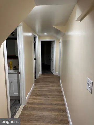 a view of an empty room with wooden floor and closet