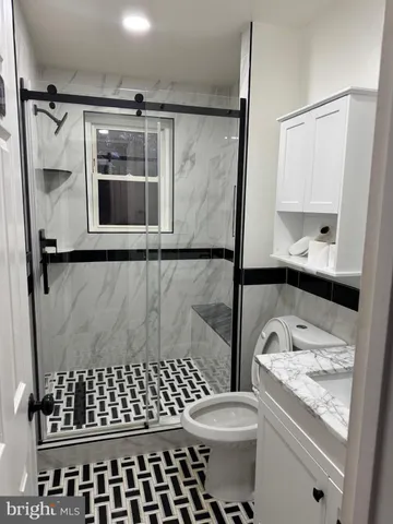 a bathroom with a granite countertop sink toilet and shower