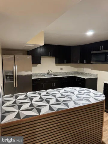 a kitchen with stainless steel appliances kitchen island granite countertop a sink and cabinets