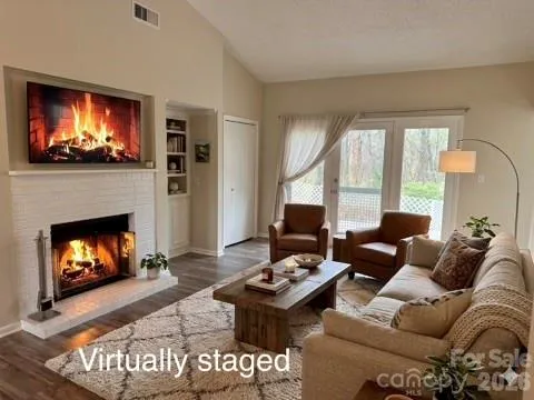 a living room with furniture a flat screen tv and a fireplace