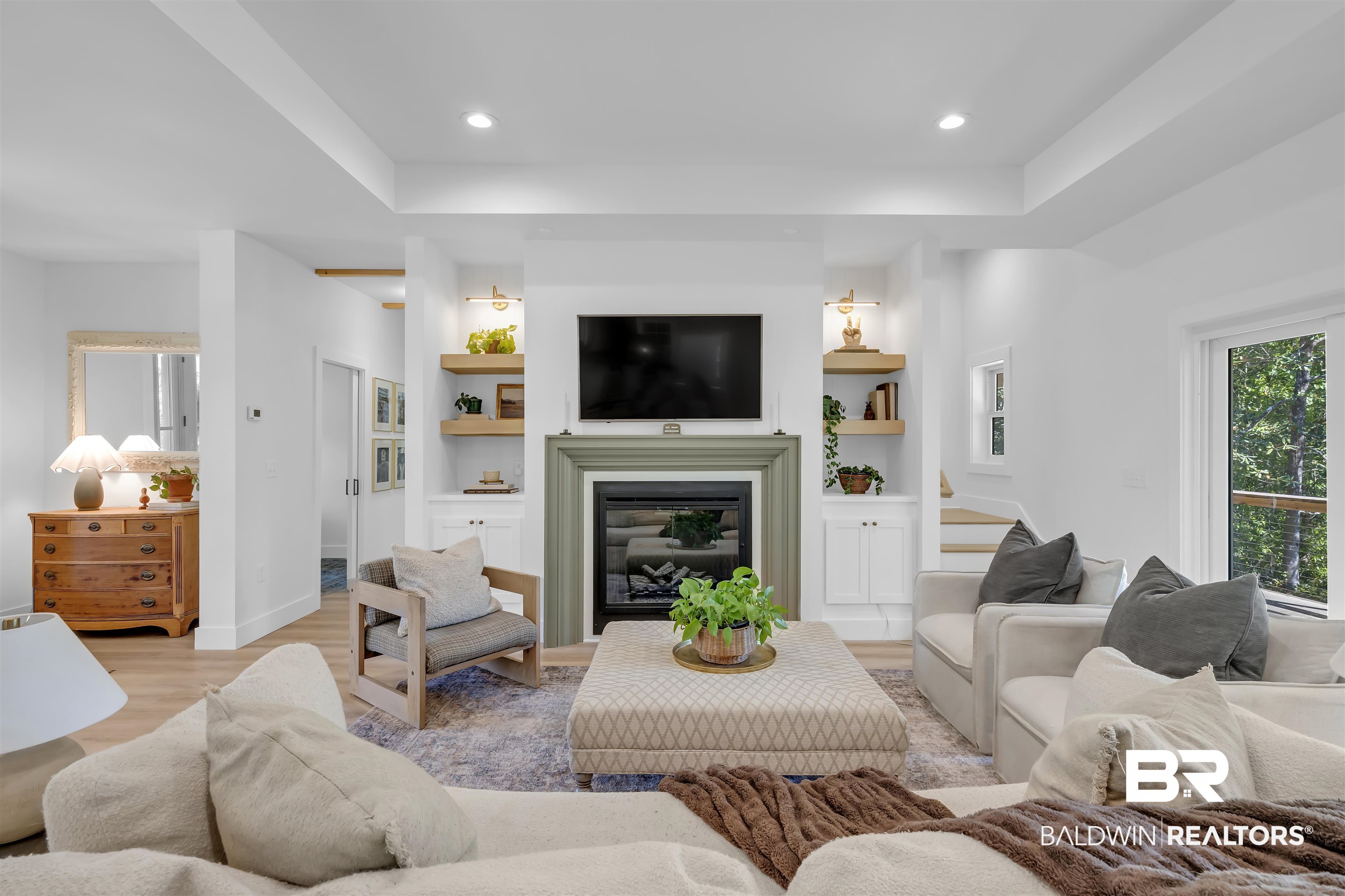 19058 James Road Gulf Shores, AL 36542 - Photo 6 of 49 Living room with built in features, recessed lighting, light wood-type flooring, a glass covered fireplace, and a raised ceiling
