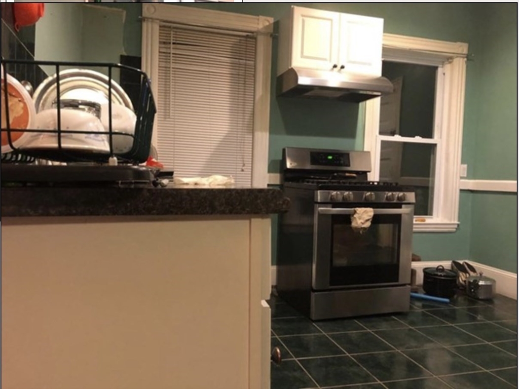 121 Main Street, Unit 1 Malden, MA 02148 - Photo 2 of 5 a kitchen with a stove and a microwave