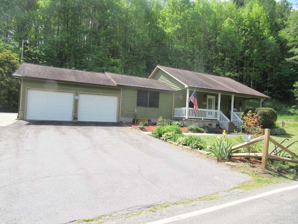 805 Ed Little Road Warrensville, NC 28693 - Photo 2 of 49 a front view of a house with a garden and plants