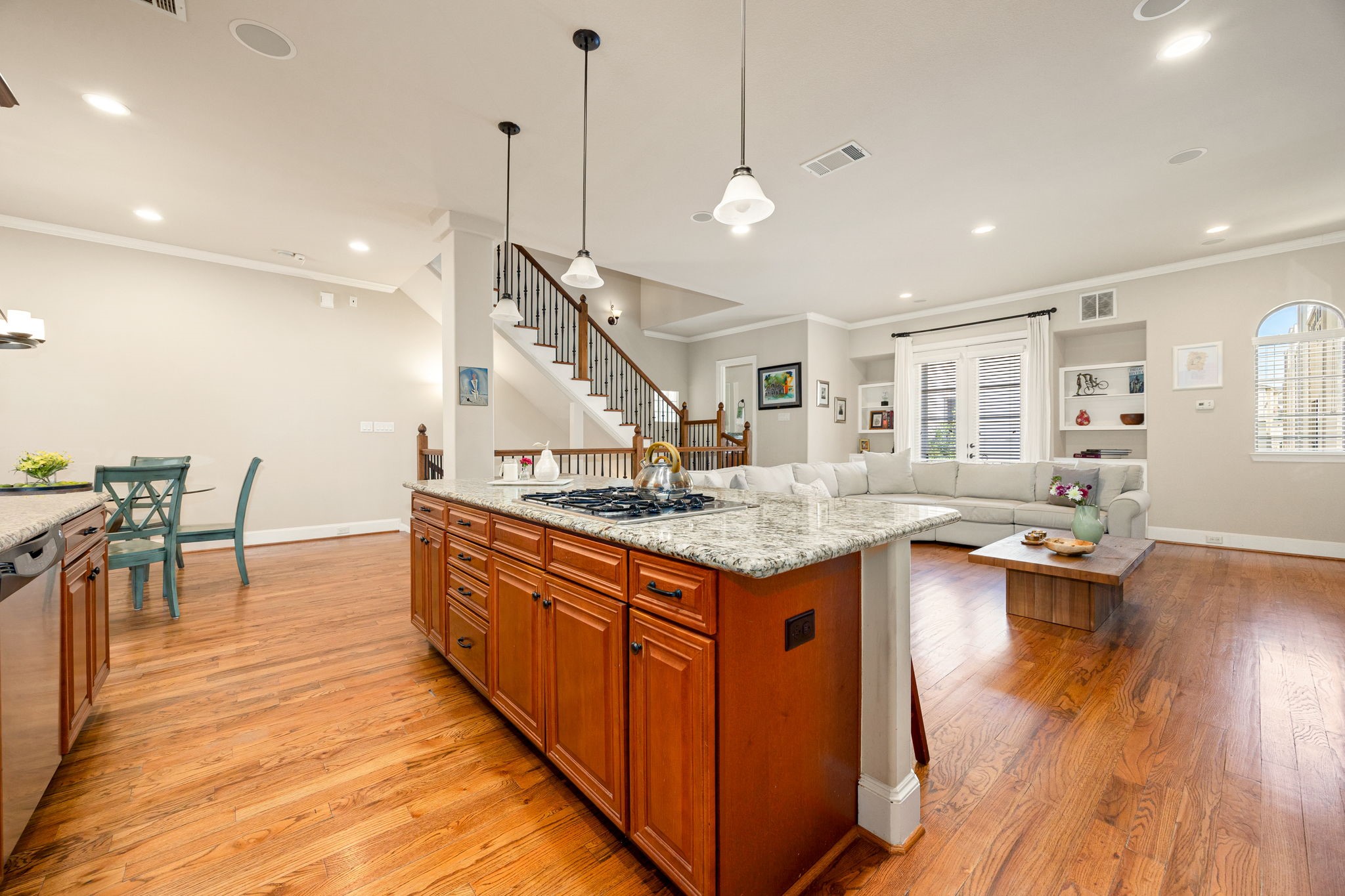 821 Lester Street Houston, TX 77007 - Photo 6 of 41 This kitchen features warm wood flooring and cabinetry, a large granite island with seating, stainless steel appliances, and modern pendant lighting. Ample natural light and and open layout that create an inviting space.