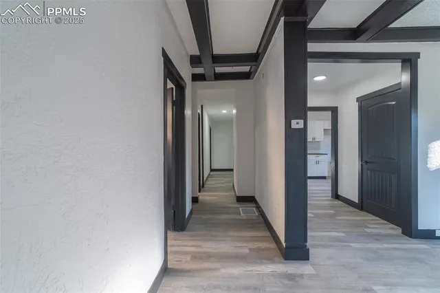 a view of a hallway with wooden floor and staircase