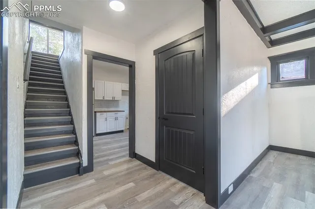 a view of a hallway with wooden floor and entryway