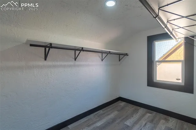 a view of hallway with window and wooden floor