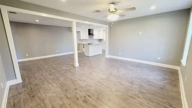 wooden floor in an empty room with a kitchen