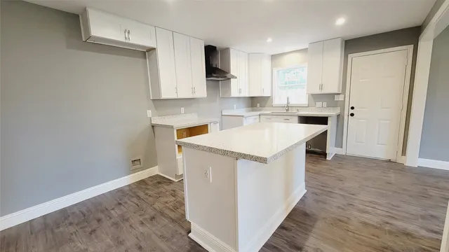 a utility room with wooden floor washer and dryer