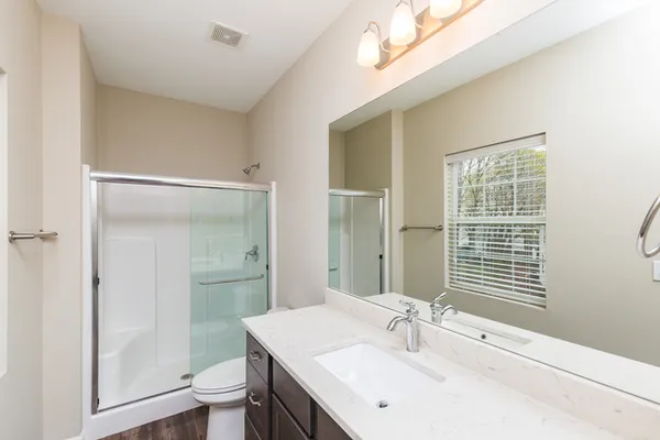 a bathroom with a sink a toilet and shower