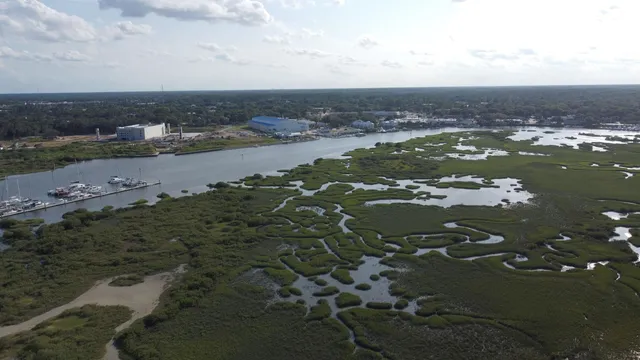 an aerial view of a houses with ocean view in back