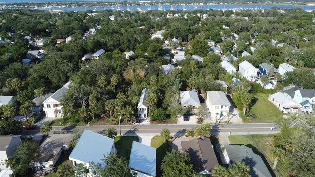 an aerial view of residential house with outdoor space and trees all around