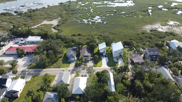 an aerial view of residential houses with outdoor space and trees