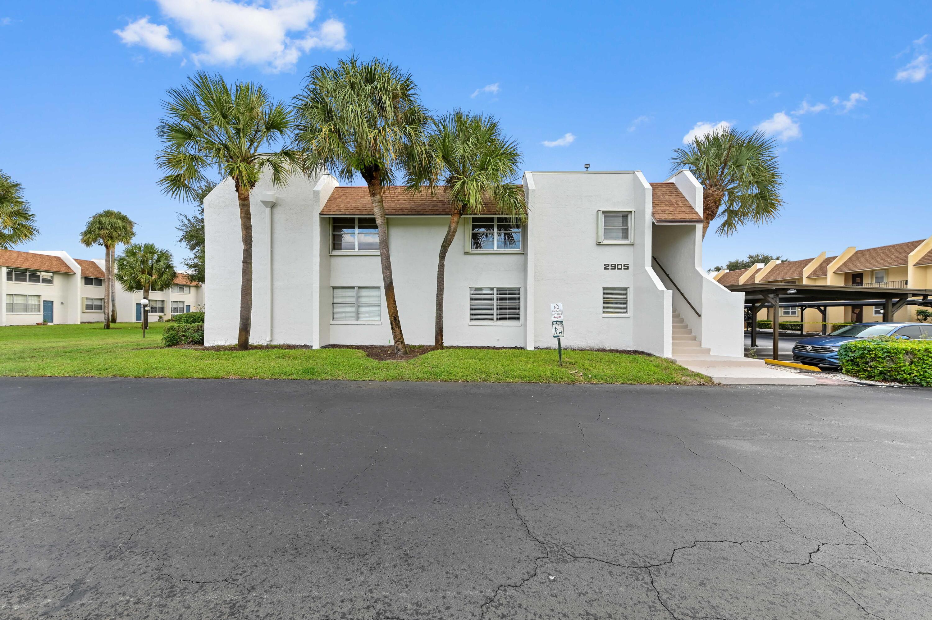 2905 Southwest 22nd Avenue, Unit 1080 Delray Beach, FL 33445 - Photo 1 of 33 a front view of multiple houses with yard