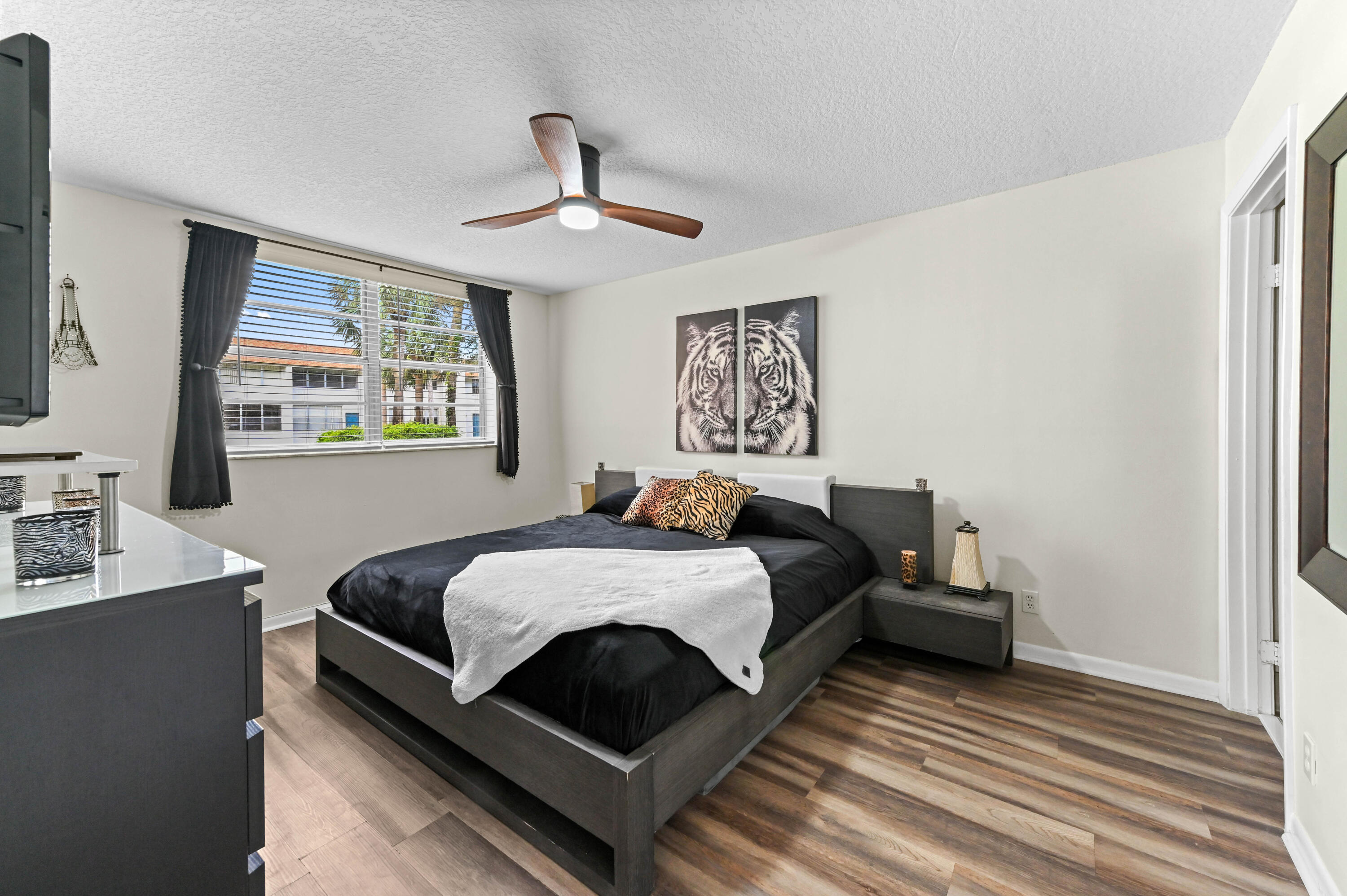 2905 Southwest 22nd Avenue, Unit 1080 Delray Beach, FL 33445 - Photo 20 of 33 a bedroom with bed and a chandelier