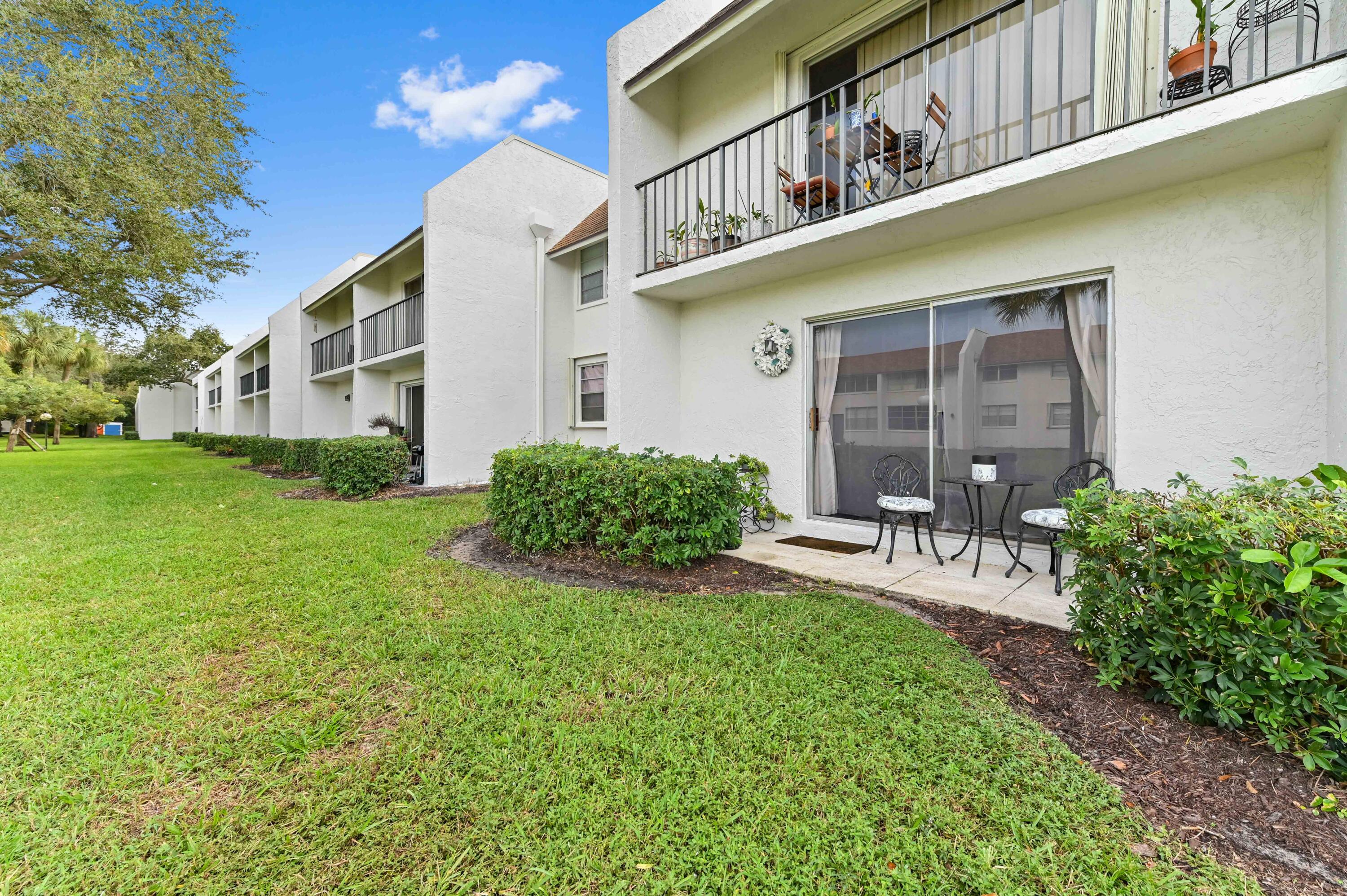 2905 Southwest 22nd Avenue, Unit 1080 Delray Beach, FL 33445 - Photo 8 of 33 a view of a house with a yard and sitting area