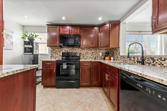 a kitchen with stainless steel appliances granite countertop a stove sink and cabinets