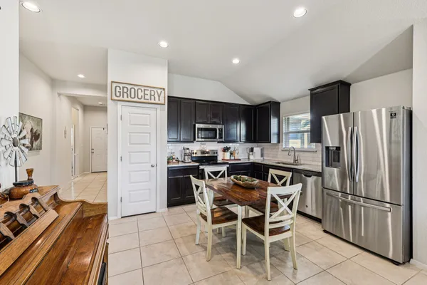 a kitchen with stainless steel appliances a refrigerator a stove a sink and dishwasher with wooden floor