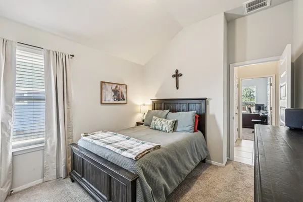 a bedroom with a bed a flat screen tv and a window
