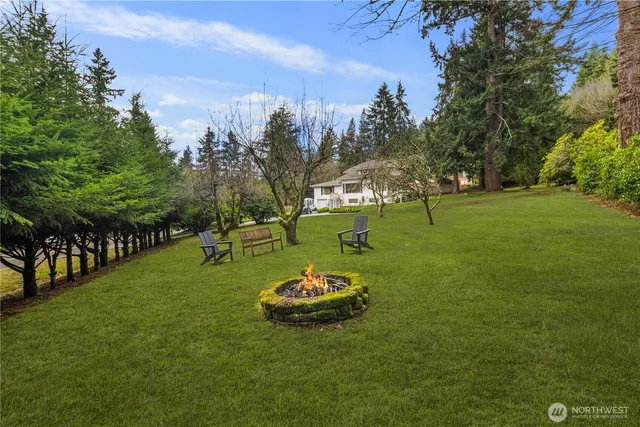 a front view of a house with a garden and trees