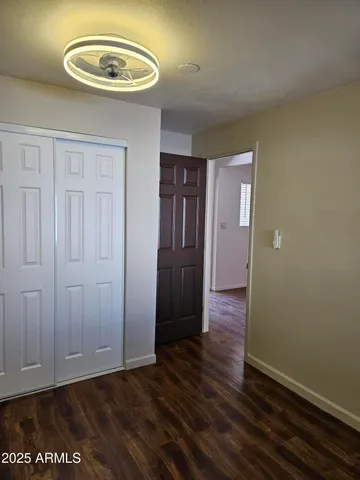 an empty room with wooden floor and closet
