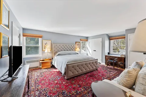 a bedroom with a bed flat screen tv and window