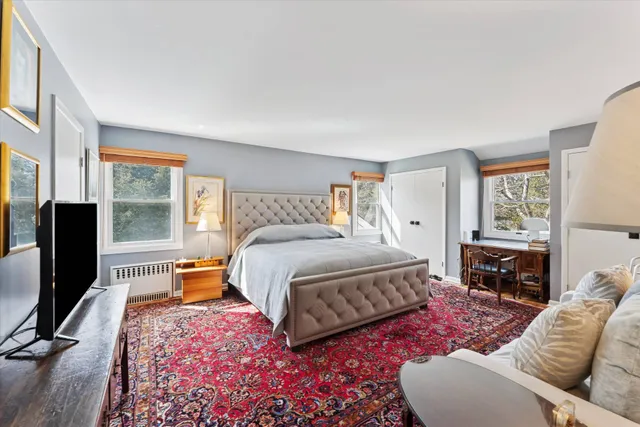 a bedroom with a bed flat screen tv and window