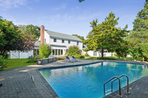 a swimming pool with outdoor seating and yard