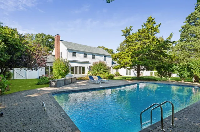 a swimming pool with outdoor seating and yard