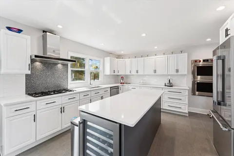 a kitchen with white cabinets and appliances