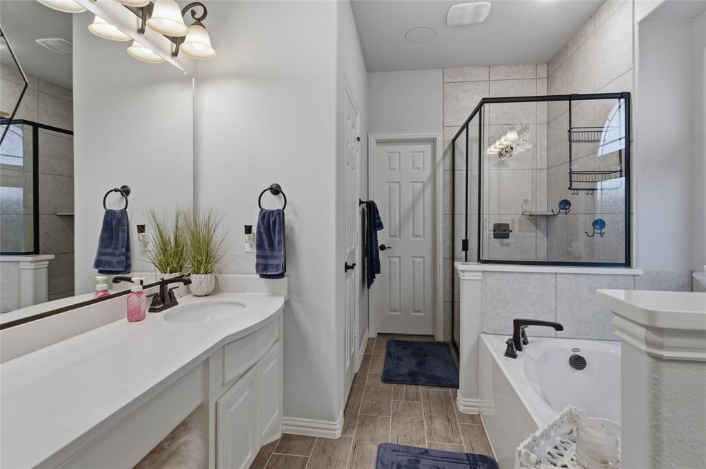 464 LeTara Ranch Drive Haslet, TX 76052 - Photo 21 of 37 Contemporary bathroom featuring a spacious vanity with an undermount sink, a large mirror, and wood-finish flooring