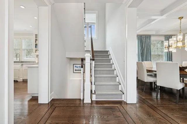 a view of a hallway with wooden floor and a chandelier