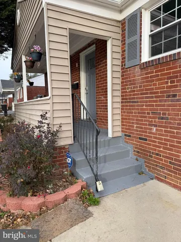 a view of a house with a small yard and wooden floor and fence