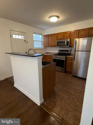 a kitchen with stainless steel appliances granite countertop a refrigerator a stove a sink and a microwave