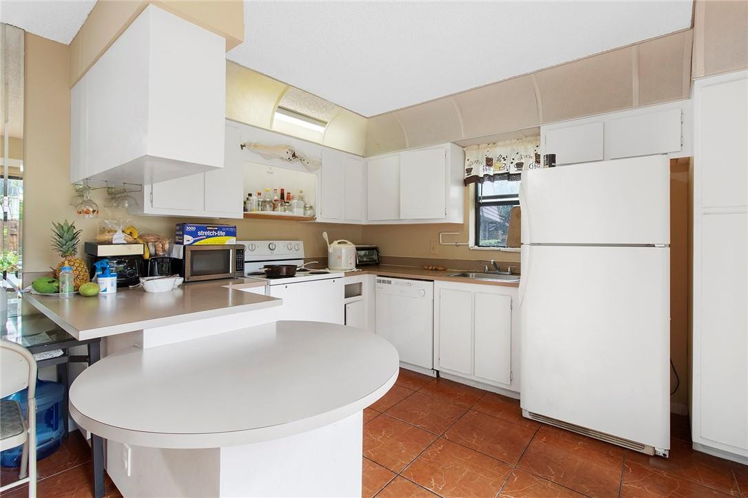7543 Courtyard Run East, Unit 7543 Boca Raton, FL 33433 - Photo 5 of 15 a kitchen with refrigerator and cabinets
