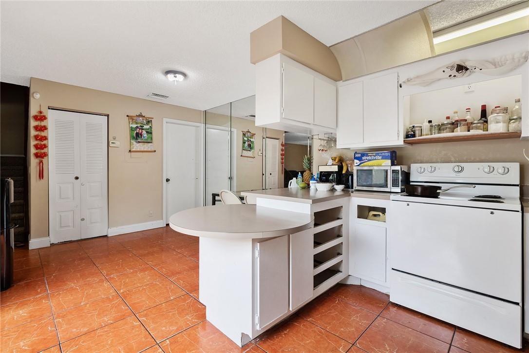 7543 Courtyard Run East, Unit 7543 Boca Raton, FL 33433 - Photo 6 of 15 a kitchen with white cabinets and appliances