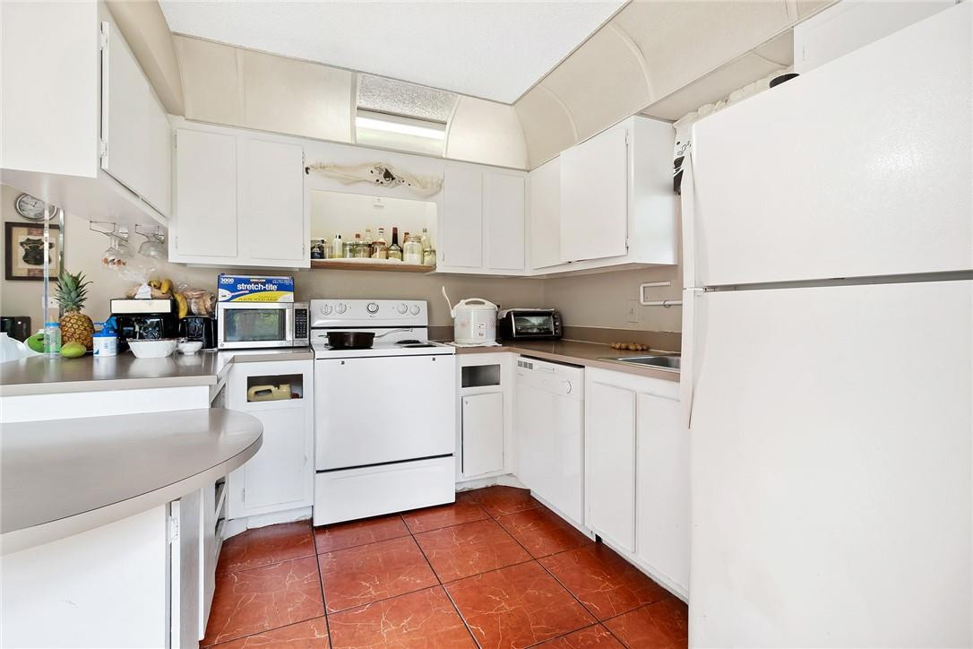 7543 Courtyard Run East, Unit 7543 Boca Raton, FL 33433 - Photo 7 of 15 a kitchen with white cabinets and white appliances