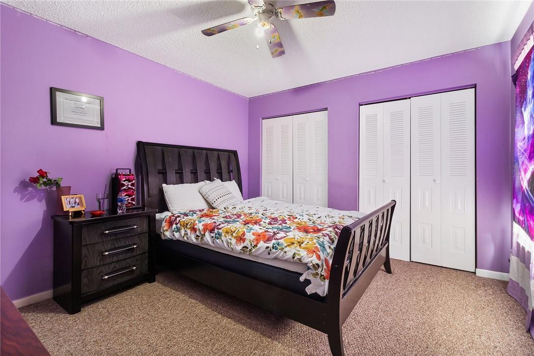 7543 Courtyard Run East, Unit 7543 Boca Raton, FL 33433 - Photo 9 of 15 a bedroom with a bed and a chandelier
