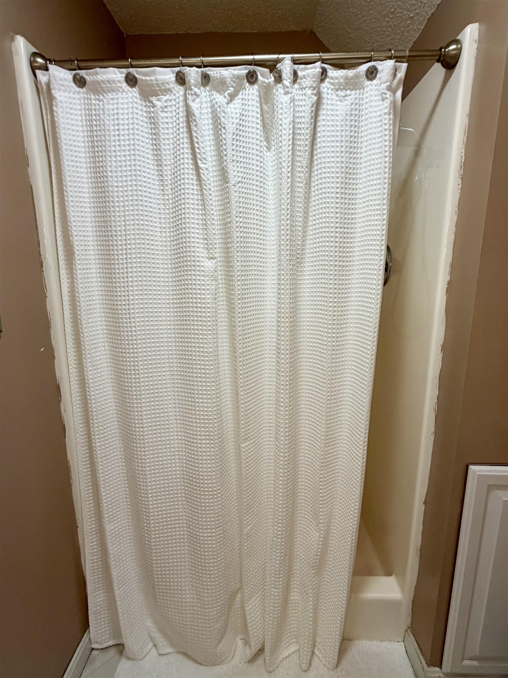 142 Treece Street Selmer, TN 38375 - Photo 24 of 36 Tub and shower combination featuring a bronze-finish shower rod and white waffle-textured shower curtain